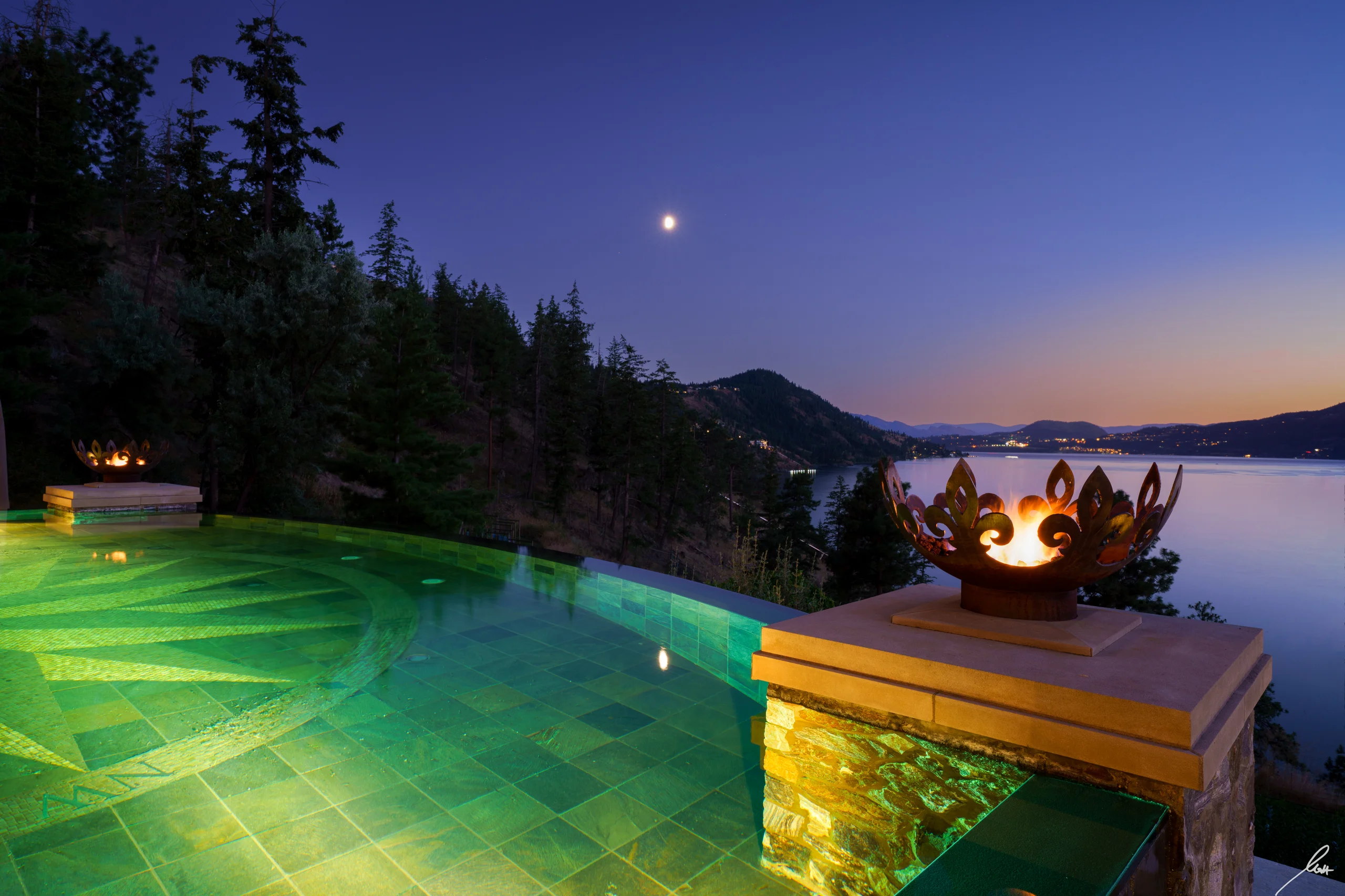 Infinity pool at twilight with fire bowl and Okanagan Lake